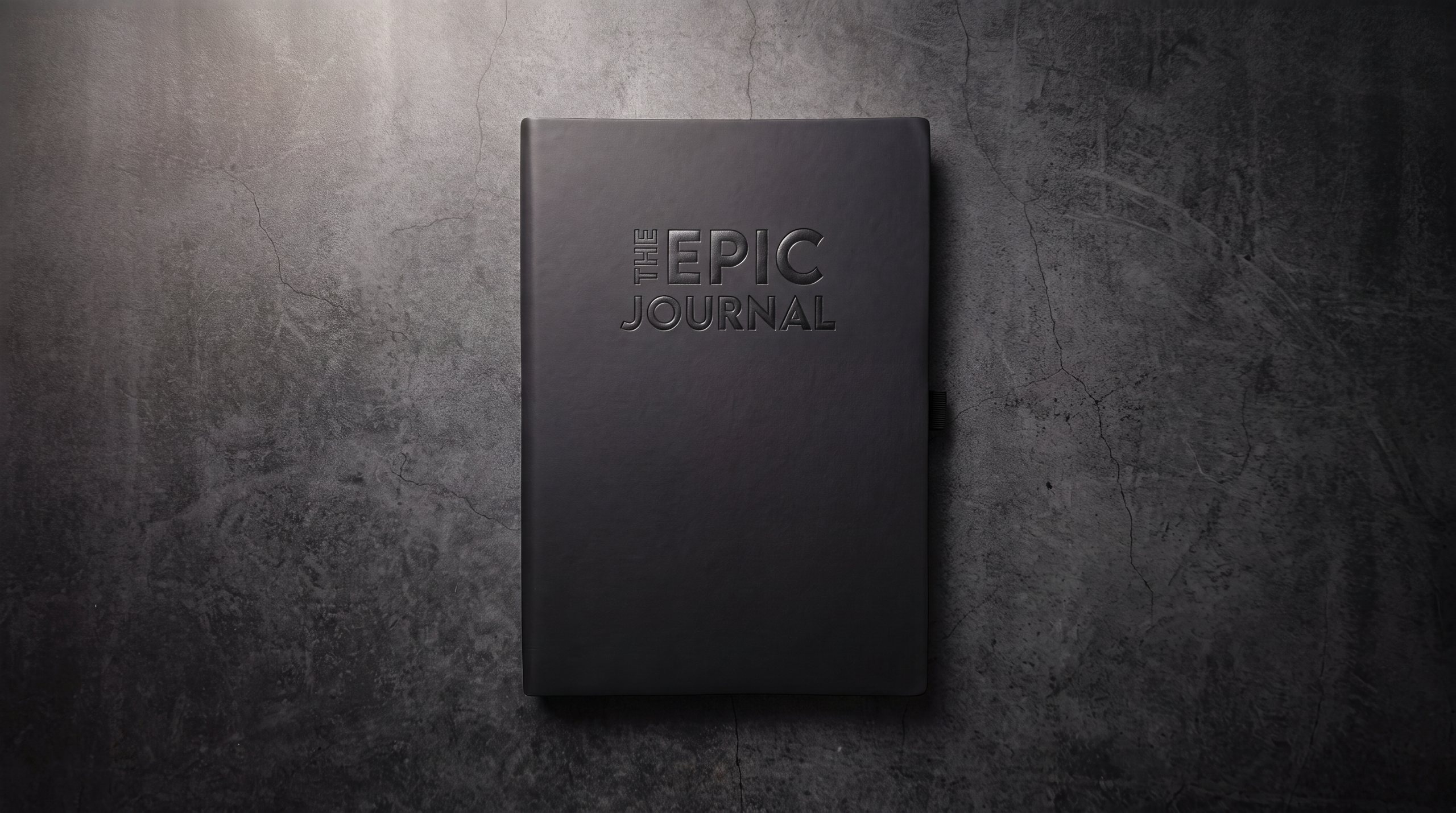 The Epic Journal's embossed black cover resting on a dark textured surface